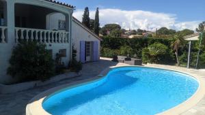 a large blue swimming pool in front of a house at Prime Rose in Saint-Aygulf