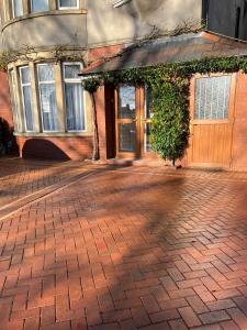 a brick sidewalk in front of a building with a door at On The Common in Cardiff