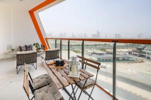 balcón con mesa y sillas y ventana grande en Frank Porter - Binghatti Avenue, en Dubái