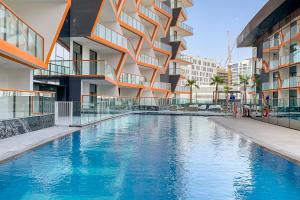 a swimming pool in front of a building at Frank Porter - Binghatti Avenue in Dubai