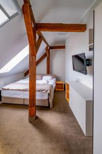 a attic bedroom with two beds and a tv at Relax Hotel Stork in Lednice