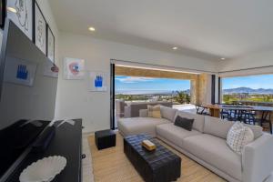 a living room with a couch and a tv and a balcony at Spacious New 3BR Condo at Tramonti plus Resort Access in Cabo San Lucas