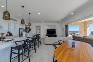 a kitchen and living room with a wooden table and chairs at Spacious New 3BR Condo at Tramonti plus Resort Access in Cabo San Lucas
