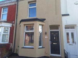 a building with a black door and windows at Large family house in Liverpool