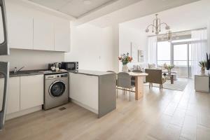 a kitchen and living room with a washing machine and a table at Frank Porter - Bloom Tower in Dubai