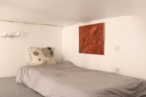 a bedroom with a bed with a painting on the wall at Cosy love nest near Gare de l'Est in Paris