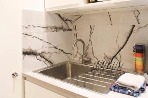 a sink in a kitchen with black and white marble at Cosy love nest near Gare de l'Est in Paris