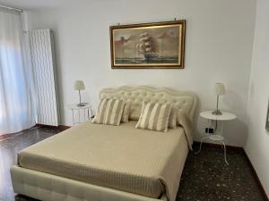 1 dormitorio con 1 cama grande con almohadas y una pintura en Ca' Delfina Holiday Home, en Venecia