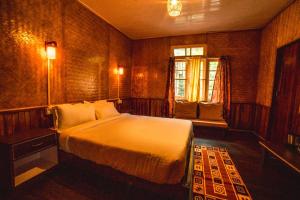 um quarto com uma cama grande e uma janela em The Basnett Croft em Gangtok