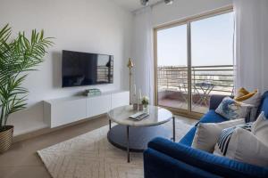 a living room with a blue couch and a table at Frank Porter - Icon Tower 1 in Dubai