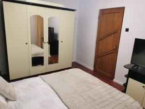 a bedroom with a mirror and a bed and a television at Amy Apartment in Piatra Neamţ