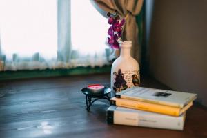 a stack of books and a vase with a flower on top at Axiokersa Suites in Samothraki