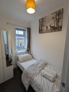 a bedroom with a bed and a picture on the wall at Fantastic 3-Bedroom House in London in Morden