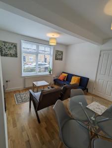 a living room with a couch and a table at Fantastic 3-Bedroom House in London in Morden