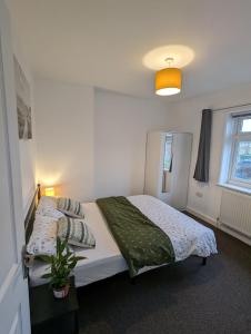 a bedroom with two beds and a potted plant at Fantastic 3-Bedroom House in London in Morden