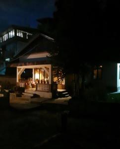 uma casa com um alpendre iluminado à noite em The Basnett Croft em Gangtok