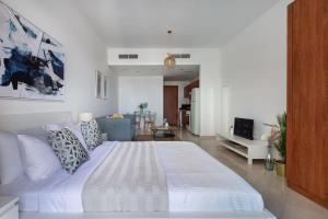 a bedroom with a large white bed and a living room at Frank Porter - Damac Crescent A in Dubai