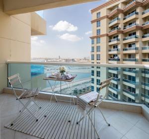 a balcony with a table and chairs and a view of a building at Frank Porter - Damac Crescent A in Dubai