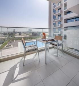 a table and chairs on a balcony with a view at Frank Porter - Azizi Aura in Dubai
