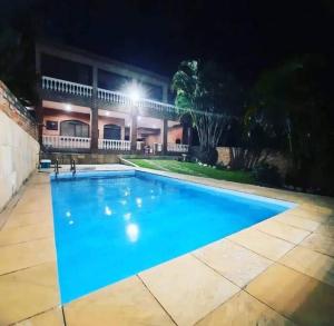 een zwembad voor een huis 's nachts bij Casa de Praia em Iguaba grande in Iguaba Grande