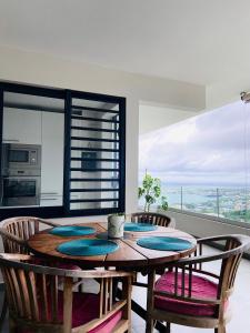 - une salle à manger avec une table et des chaises en bois dans l'établissement Meherio - Bel Appartement vue mer à TAHITI, à Papeete