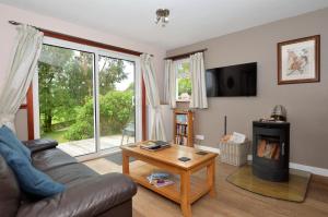 ein Wohnzimmer mit einem Sofa und einem Holzofen in der Unterkunft Rowan Cottage in Blairmore