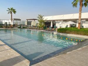 a swimming pool in front of a building at Frank Porter - Damac Sycamore in Dubai