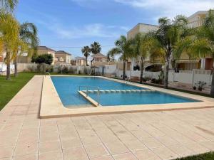 a large swimming pool in a yard with palm trees at Awesome Villa in El Moncayo with 3 Bedrooms in El Moncayo