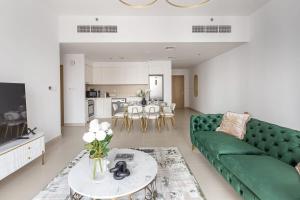 uma sala de estar com um sofá verde e uma mesa em Frank Porter - Creek Horizon Tower 2 em Dubai