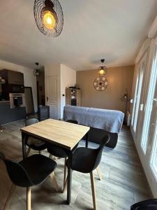 a living room with a wooden table and chairs at Location appartement estivale in Montagnac