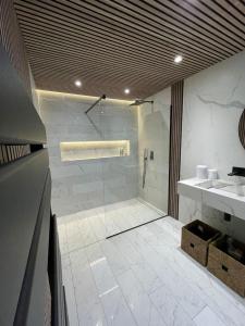 La salle de bains est pourvue d'une douche, de 2 lavabos et d'une douche en verre. dans l'établissement Villa de 4 chambres avec piscine privee jardin clos et wifi a Vouzeron, à Vouzeron