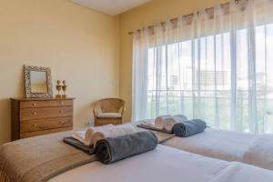 2 Betten in einem Schlafzimmer mit Fenster in der Unterkunft Açor in Ponta Delgada