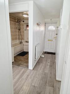 a bathroom with a white door and a bath tub at 2 Bedroom Cozy Chambers with free parking in Leeds +27 photos