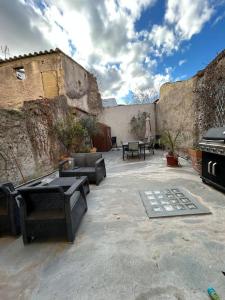 a patio with furniture and a grill in a building at Location appartement estivale in Montagnac