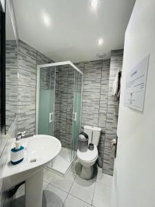 a bathroom with a toilet and a sink and a shower at Ludotel in Belley