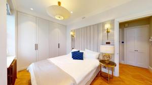 a bedroom with a white bed and a table at The Wimpole IX - 1 bed flat in London