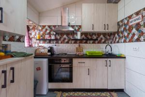 uma cozinha com armários de madeira e um forno com placa de fogão em Brvnara Iverak em Mokra Gora