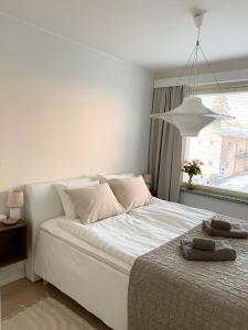 um quarto com uma grande cama branca e uma janela em Seaside apt with parking space, close to metro (6mins from city centre) em Helsinque