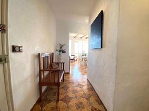 un couloir avec une chaise et une télévision murale dans l'établissement La Casa del Artista, à Altea