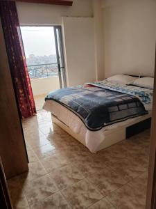 um quarto com uma cama e uma grande janela em Villa Sotiri em Sarandë