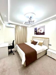 a bedroom with a large bed and a desk at Duplex familial 3 chambres au cœur de la Corniche de Tanger in Tangier