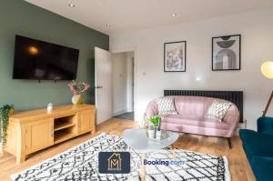 a living room with a pink couch and a tv at 3 Bed Apartment By Movida Property Group Short Lets & Serviced Accommodation Harrogate in Harrogate
