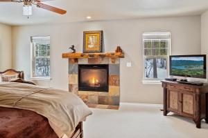 a bedroom with a fireplace with a television and a bed at 30-Day Min Near Lake and Downtown Whitefish in Whitefish