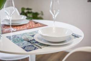 una mesa blanca con un tazón y platos en ella en Suite649 Nuova 5 en Modena
