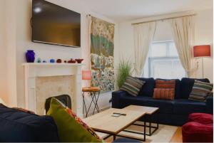 a living room with a blue couch and a table at Buxton Mews in Ulverston