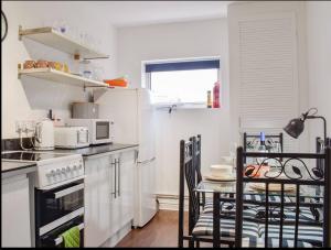 a kitchen with a table with chairs and a stove at Buxton Mews in Ulverston