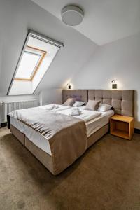 a bedroom with a large bed and a window at Relax Hotel Stork in Lednice