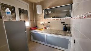 a small kitchen with a sink and a refrigerator at Appartement centre de Taghazout 2 -WiFi in Taghazout
