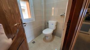 a small bathroom with a toilet and a window at Appartement centre de Taghazout 2 -WiFi in Taghazout