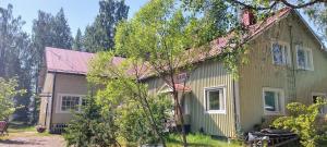 an old green house with a red roof at Hyvän Elämän Koulun huoneisto Good Life Homestay Apartment in Ahmovaara